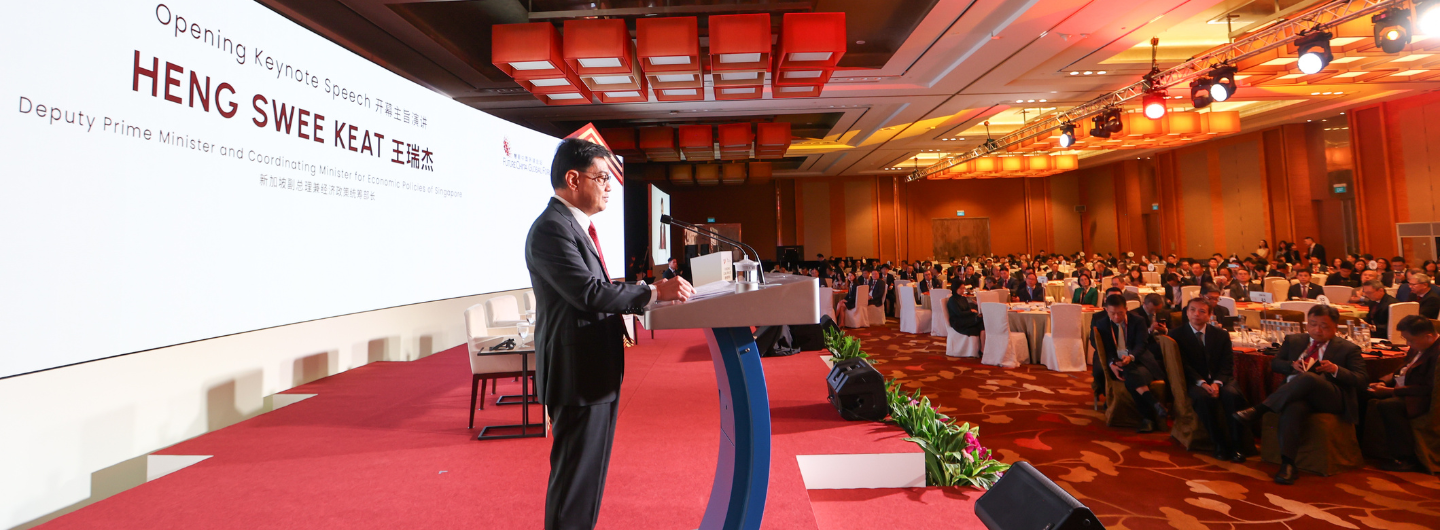 Heng Swee Keat at podium addressing audience, presentation displayed behind.